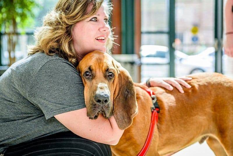 Woman hugging a hound dog